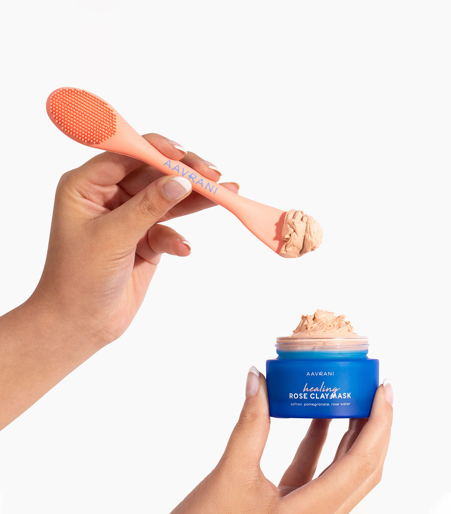 AAVRANI Healing Rose Clay Mask and Mask Applicator Tool being scooped out of jar by model